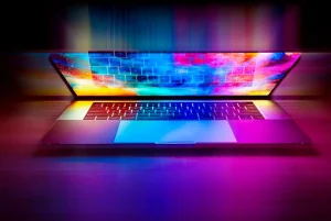 Mężczyzna przegląda strony internetowe na eleganckim laptopie w nowoczesnym biurze, co ilustruje wybór idealnego laptopa do pracy i rozrywki.